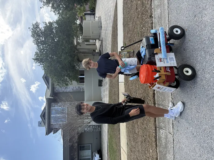 Youth entrepreneurs posing with their wagon of supplies